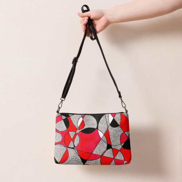 Kézzel rajzolt geometrikus mintás crossbody táska, állítható pánttal és cipzáras záródással, letisztult stílusban, merész színekkel.